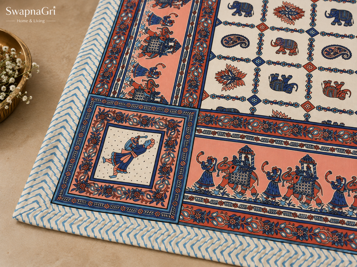 Fabric close-up showing blue elephants, coral flowers, paisley motifs and decorative border
