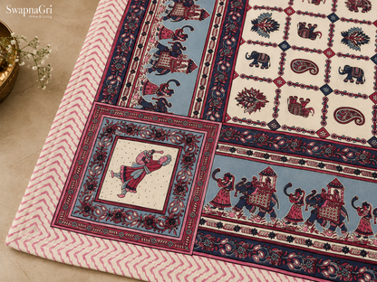 Detailed view of pink and blue decorative floral border and elephant procession print on cotton bedsheet