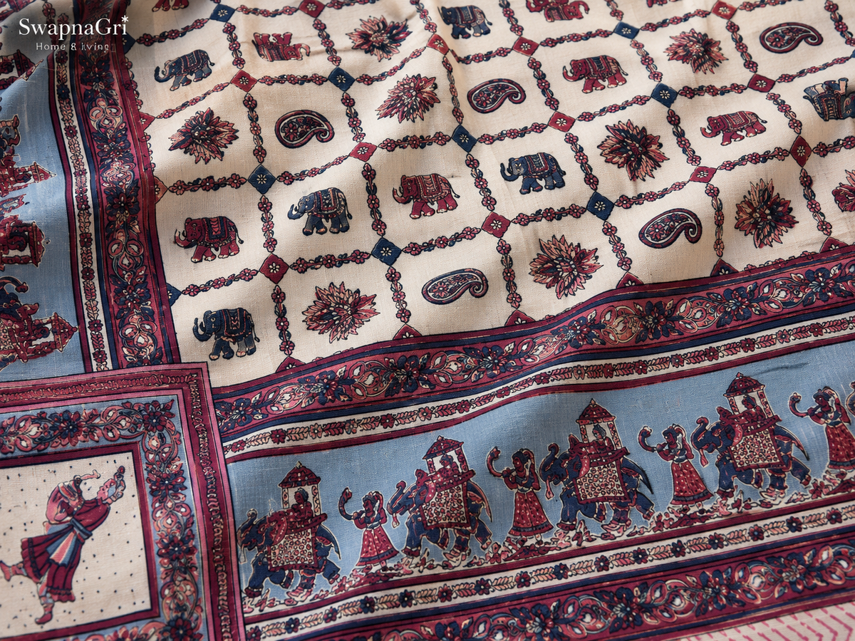 Close-up of cotton fabric with elephant, floral and paisley motifs in pink, blue and cream